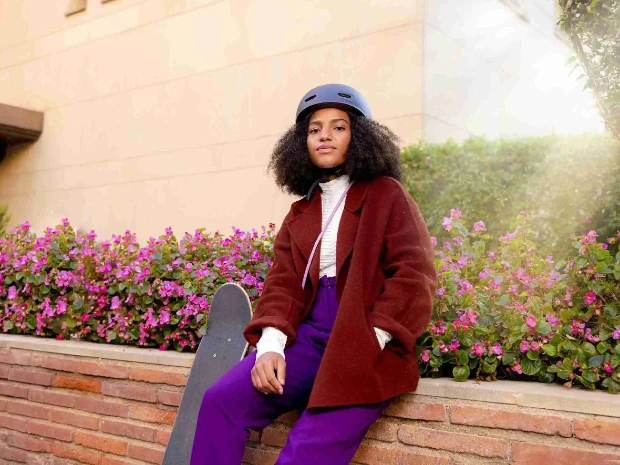 A woman confidently standing outdoors.